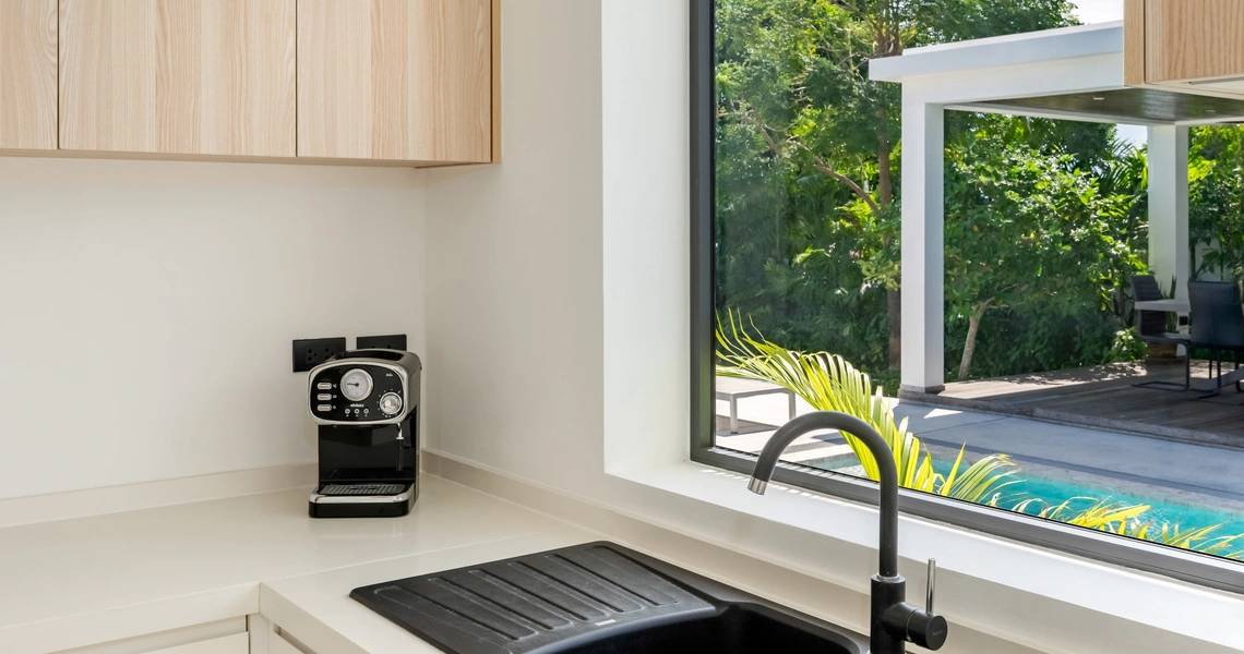 Hideway Villa Samui - kitchen sink and coffee machine against the window overlooking the pool and garden area