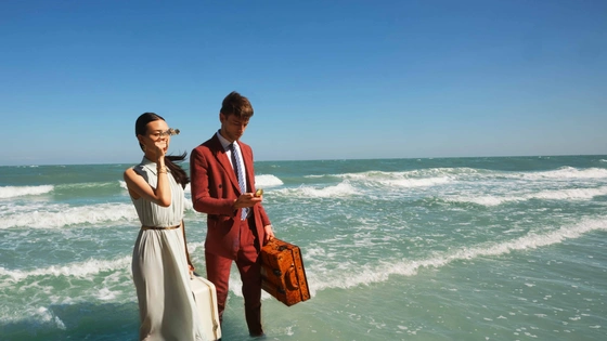 An attractive couple standing knee deep in a sea water waiting for presale of The Standard Residences Phuket to start