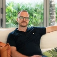 A handsome man sitting on a couch.